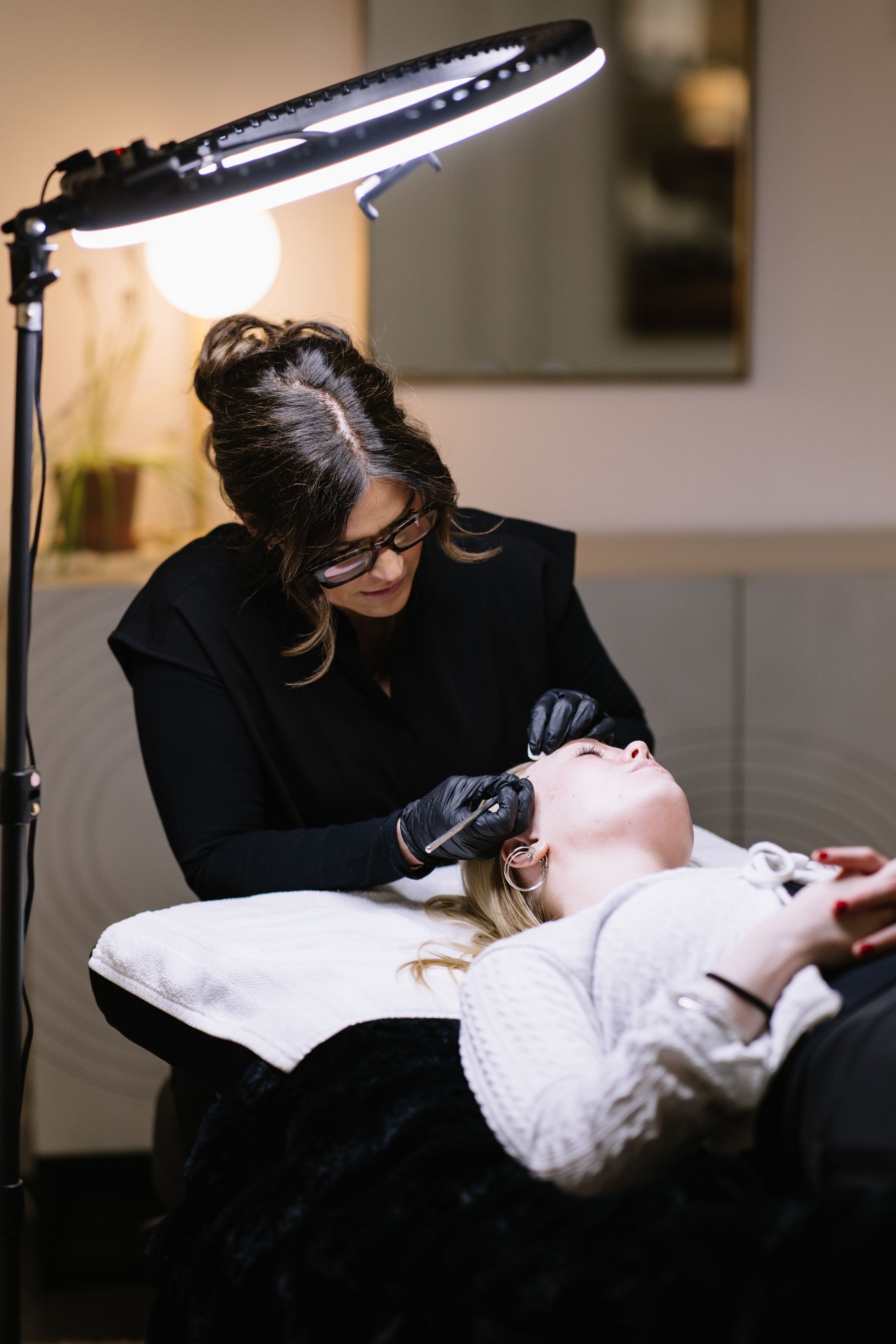 Esthetician providing a focused facial treatment